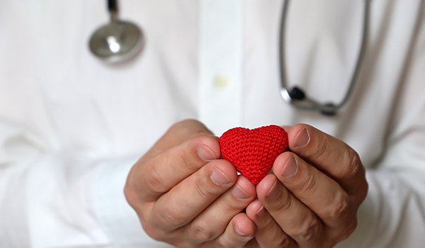 healthcare provider holding a small knitted heart